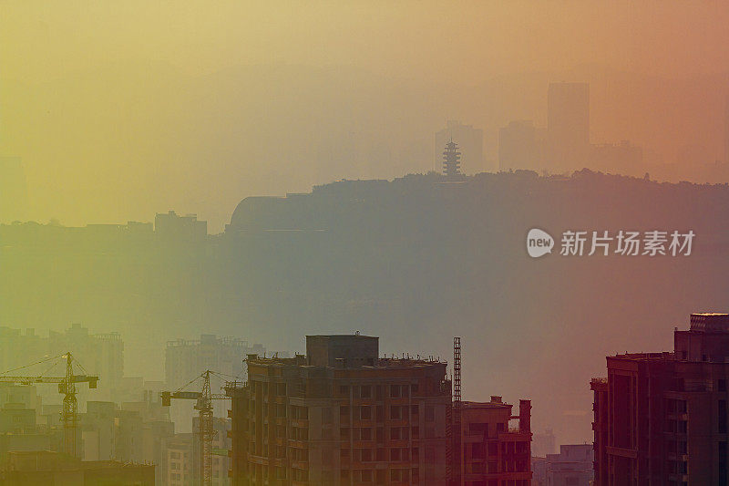 模糊的城市景观在日落的薄雾中。中国城市重庆。