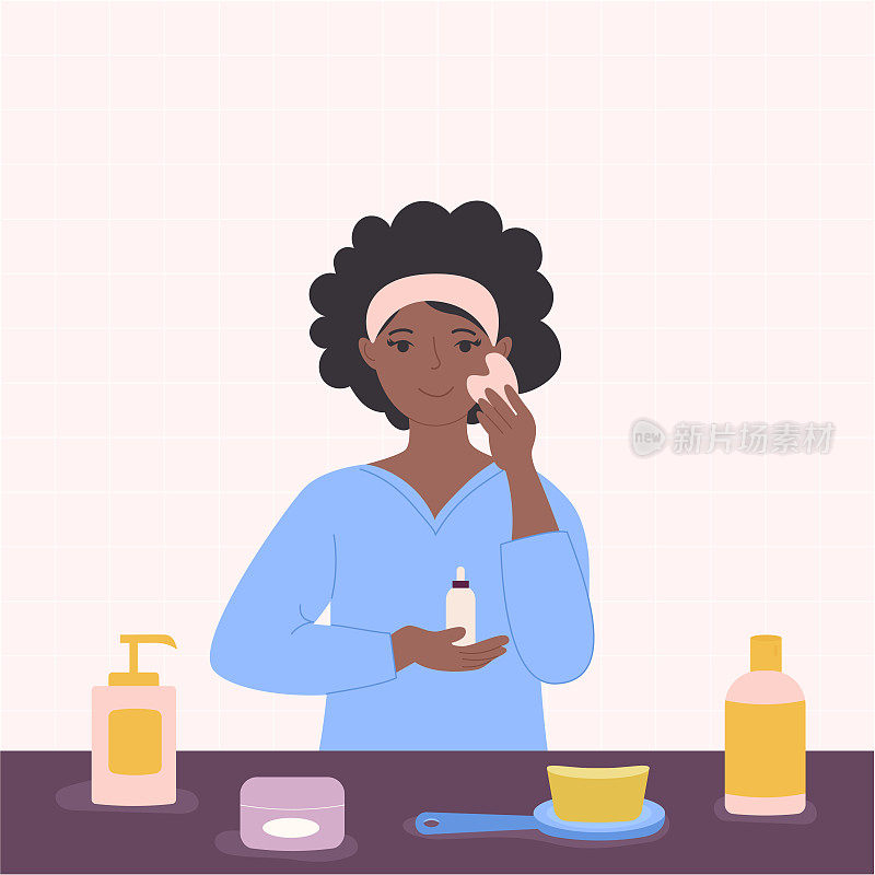 一名非洲裔美国黑人妇女在浴室里涂抹精华液，用洗涤器按摩。