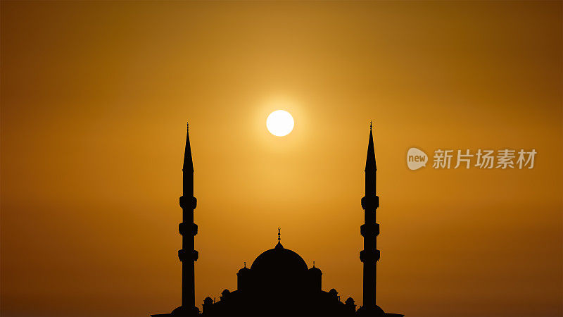 轮廓伊斯兰清真寺与圆顶和两座塔的背景日出