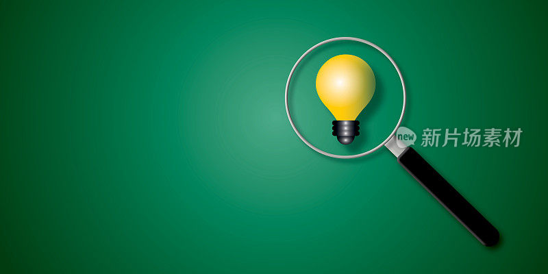 放大镜聚焦在绿色背景上的黄色灯泡。想法启发商业金融的概念。