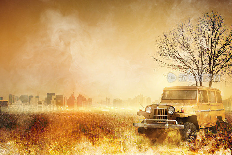 吉普车在干旱的草地和城市背景。野火燃烧的树木在夜间呈橙色和蓝色，造成空气污染的粉尘PM2.5。