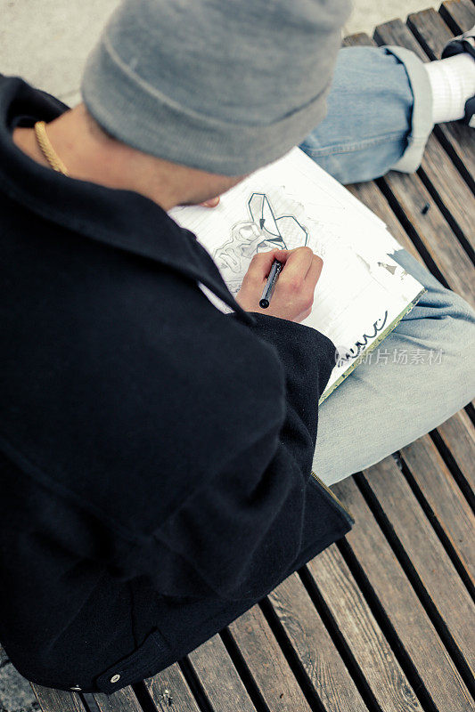 年轻的涂鸦艺术家在户外画素描