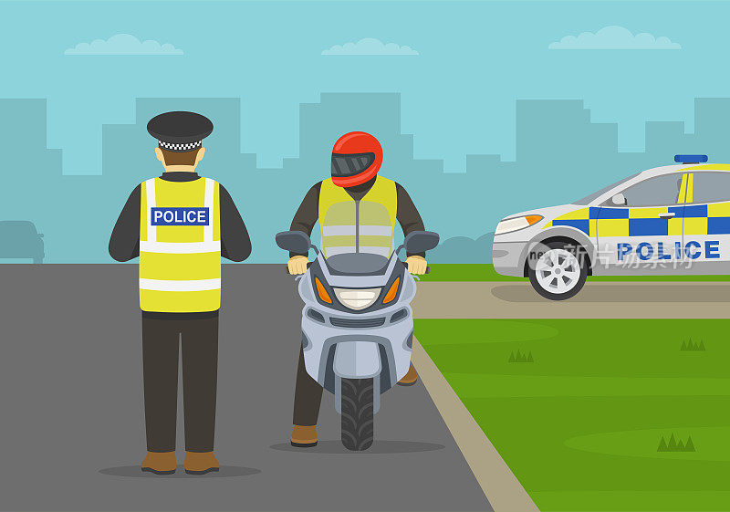 一名英国交通警察在城市道路上让一名骑摩托车的人靠边停车并检查驾驶执照。