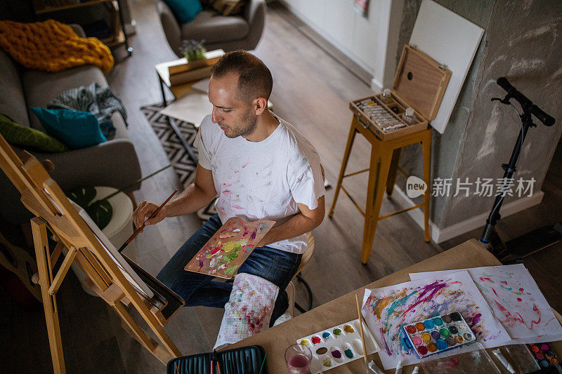 年轻艺术家在他的艺术公寓里画画