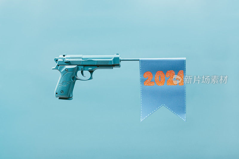 玩具枪的枪管上挂着写着“2021”的旗帜