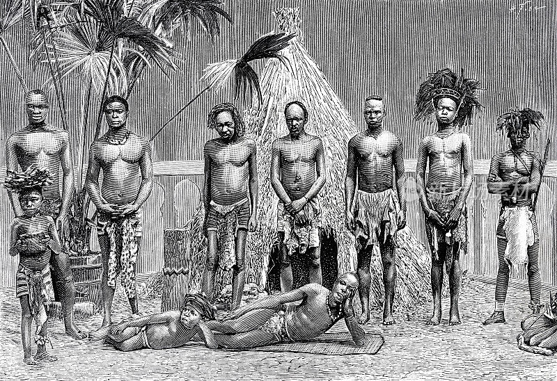 1889年世界博览会，来自安哥拉的人们在茅草屋前排成一排