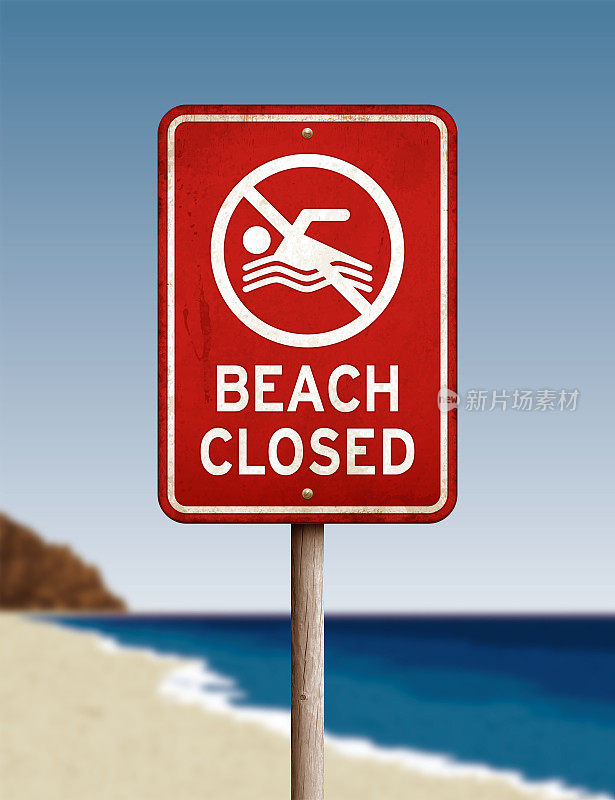 模糊的海滩背景上，风化的“海滩关闭”警告标志