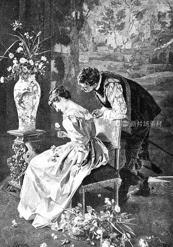 一对年轻夫妇坐在椅子上，男人在一个年轻女人后面看玫瑰