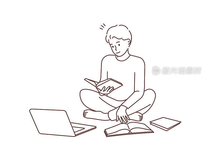 男人看书和笔记本电脑学习