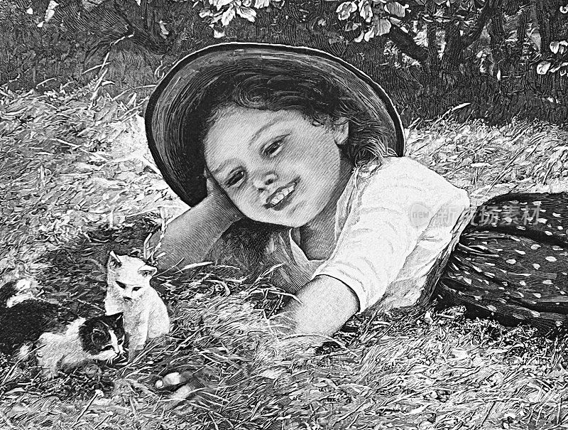 女孩躺在草地上看着两只小猫