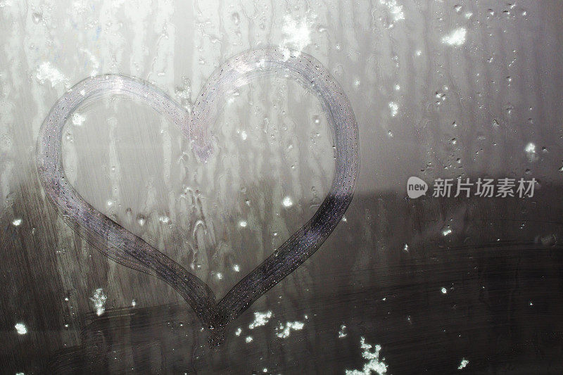 湿玻璃上的心上粘着的雪。