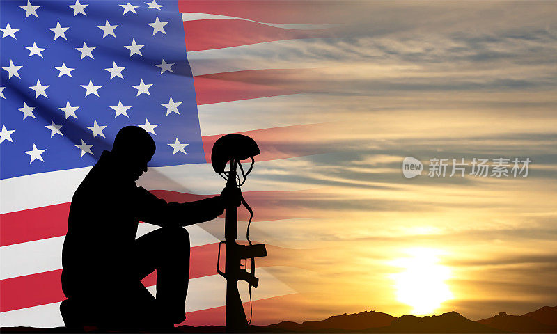 士兵跪在美国国旗的剪影