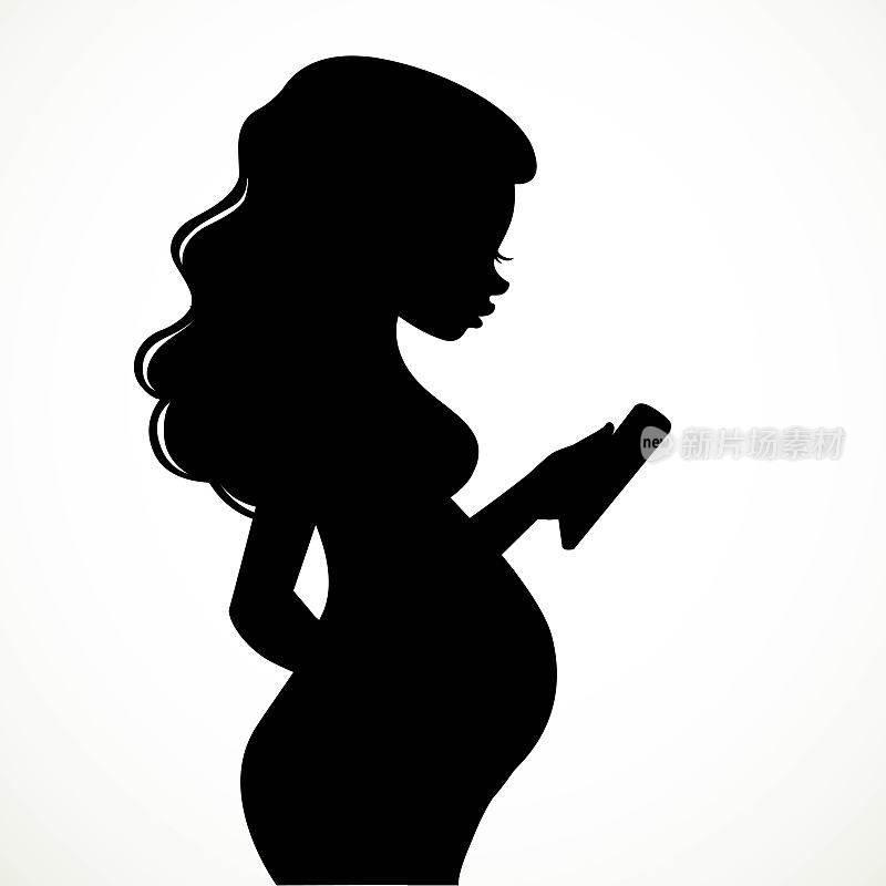 美丽的年轻孕妇剪影使用手机