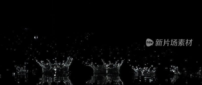 合成序列的水滴飞溅和水滴在一个黑色的背景和反射表面