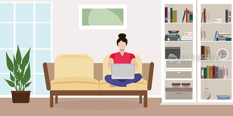 在家工作的概念。一个女人坐在沙发上拿着笔记本电脑。客厅内部有衣柜，窗户，植物，书籍