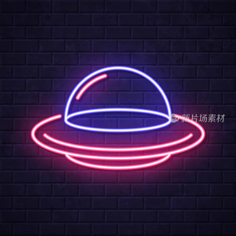 UFO――飞碟。在砖墙背景上发光的霓虹灯图标