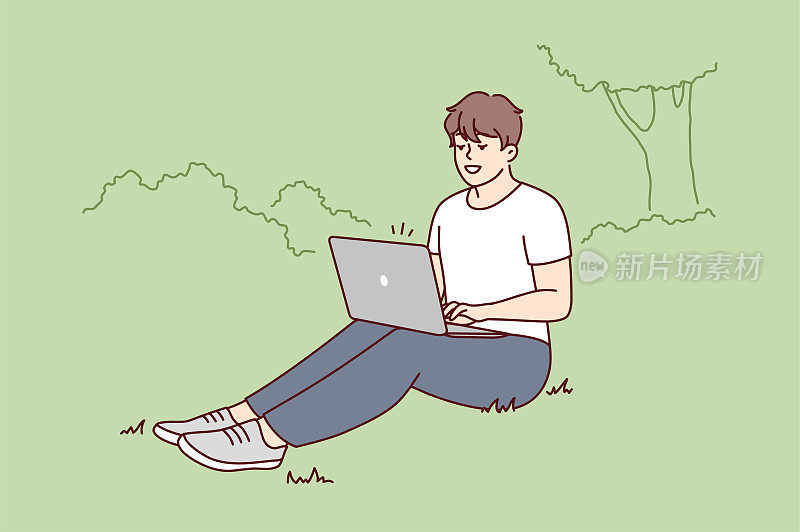微笑的男人坐在公园里用笔记本电脑工作