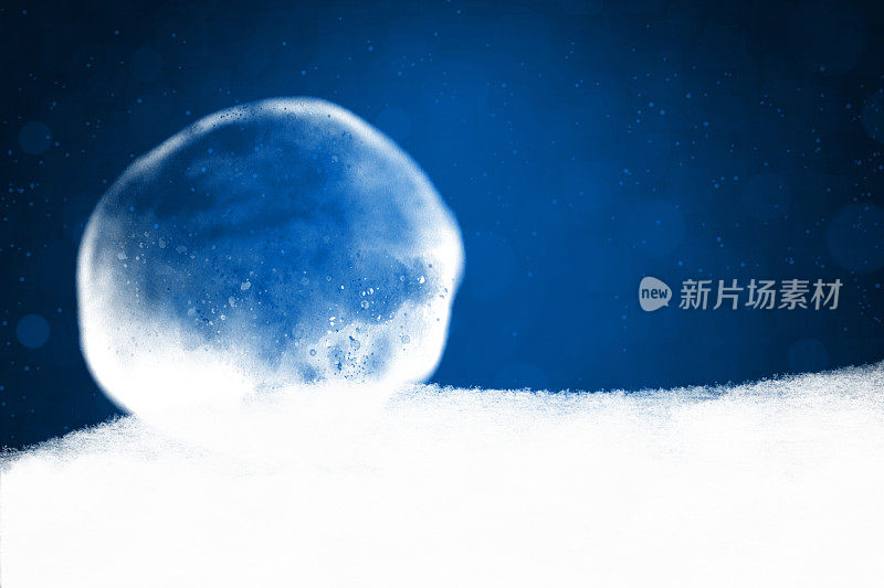 空白空午夜深宝蓝色的圣诞背景与一个大的白色褪色艺术半透明水晶球或透明气泡在一个雪皑皑的雾缕基地与地面上的烟