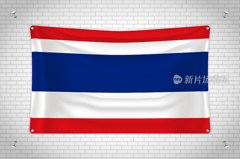泰国国旗挂在砖墙上。