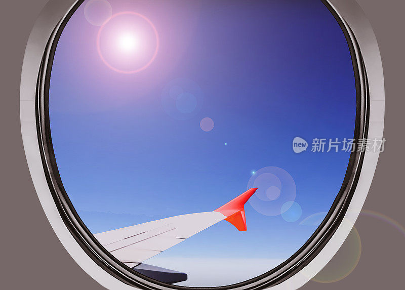 飞机窗口视图在白天飞行云层与太阳和蓝天为背景