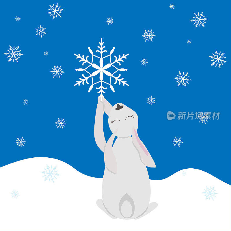 白兔在雪地里抓住飘落的雪花。