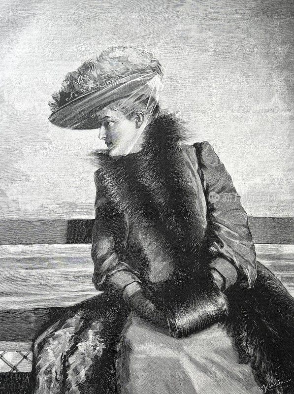 优雅的女人戴着帽子坐在船甲板上，斜着眼睛看