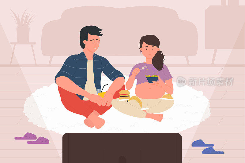怀孕的妻子和丈夫看电视剧或电影，夫妻俩坐在地毯上吃饭
