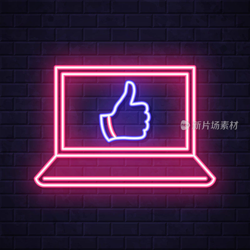 拇指点赞的笔记本电脑。在砖墙背景上发光的霓虹灯图标