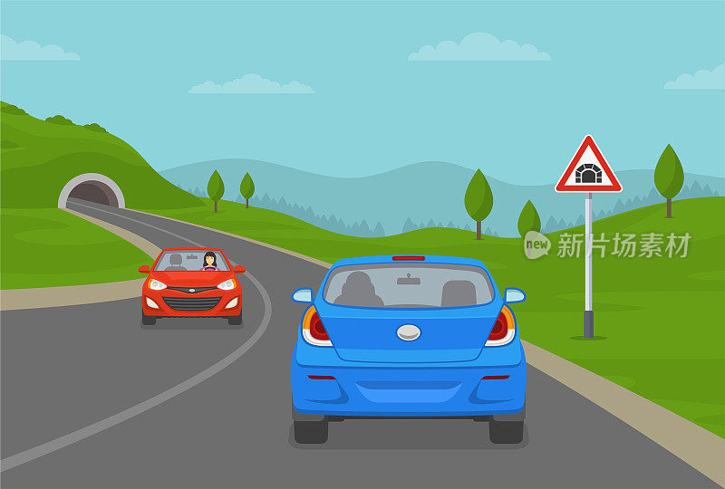 蓝色轿车驶入山路隧道。隧道前方警告道路或交通标志。