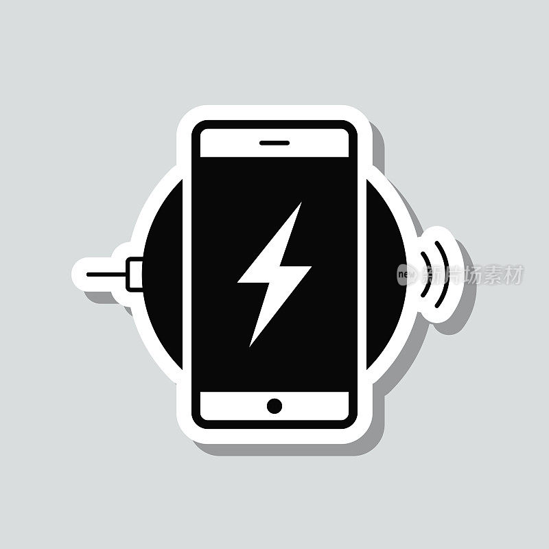 智能手机使用无线充电器充电。灰色背景上的图标贴纸