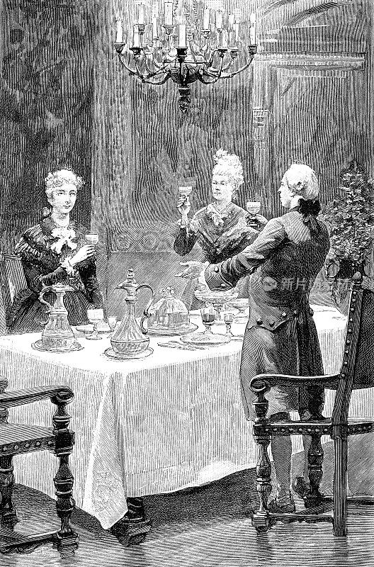 一个男人和两个女人站在餐桌前互相敬酒