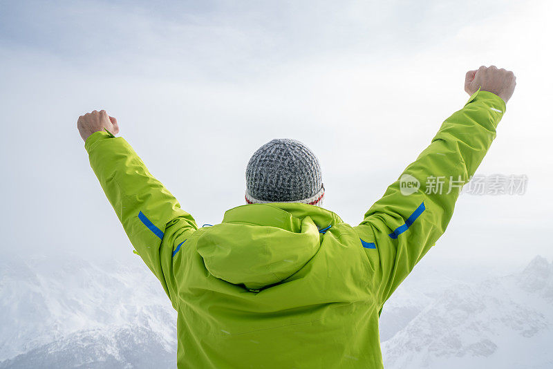 一个年轻人在滑雪坡上伸开双臂