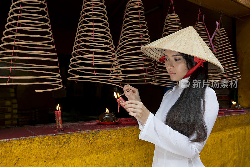 一个女孩在中国寺庙点香