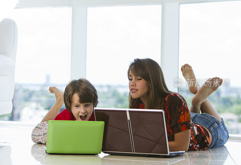 一个女孩和一个小学男孩在用笔记本电脑