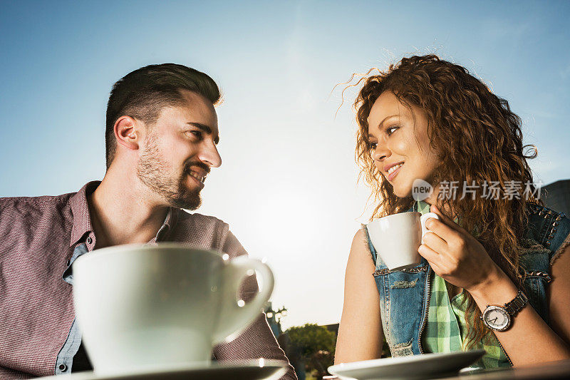 微笑的夫妇在咖啡馆聊天。