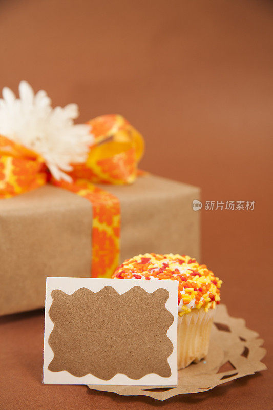 用棕色和橙色包装的礼物。生日蛋糕。