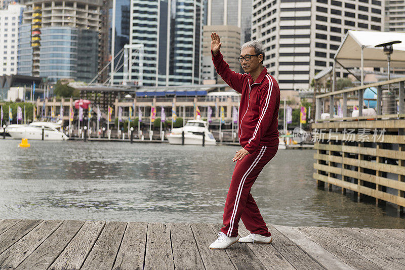 成熟的中国男子在码头边练习太极拳