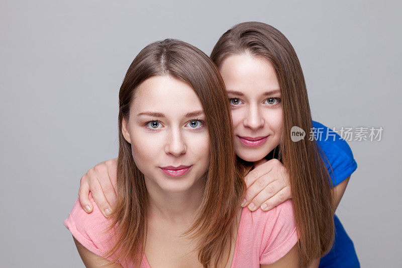 一对双胞胎姐妹拥抱在一起的照片