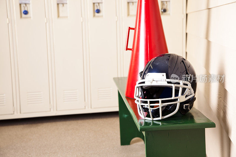 足球头盔和扩音器放在板凳更衣室