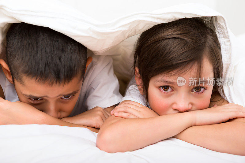 小男孩和小女孩在床上哭泣
