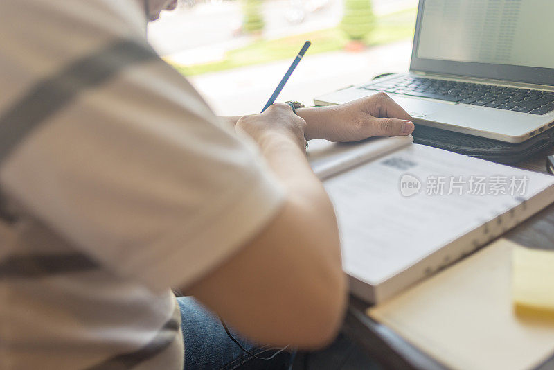 年轻的学生在他的书里写笔记