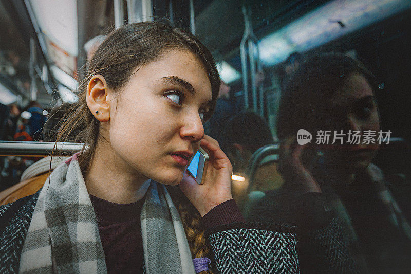 年轻女子在地铁上使用手机