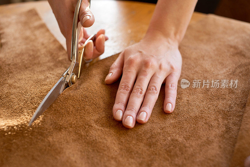 工匠用剪刀切割皮革