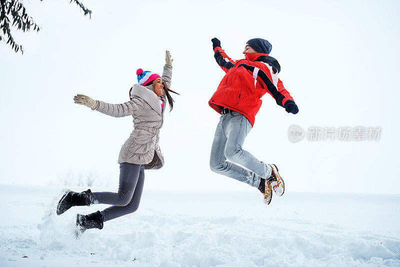 美丽的夫妇在户外玩雪。