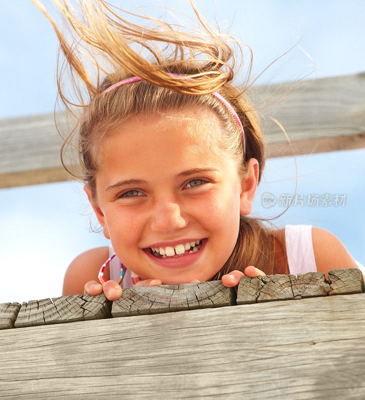 一个可爱的十几岁的女孩躺在一个风的一天的桥上的特写