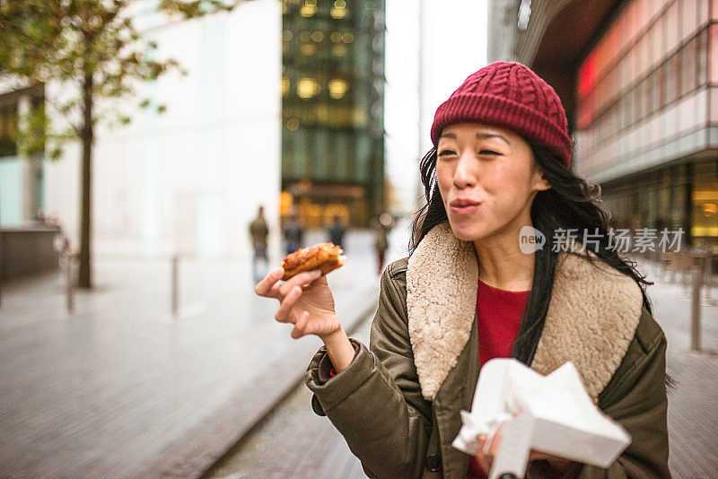 一个中国女人在街上吃零食