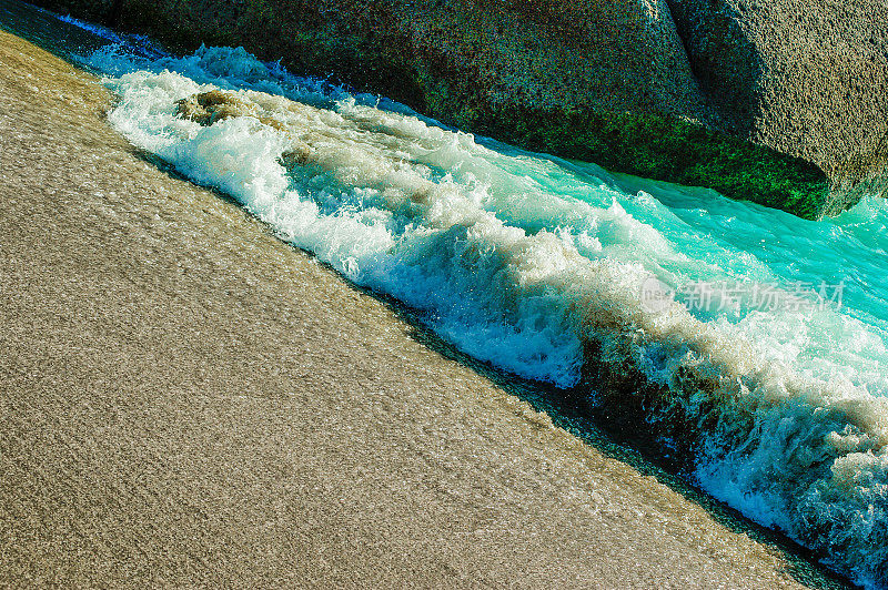 绿松石蓝色的海浪在热带海滩溅起水花的特写