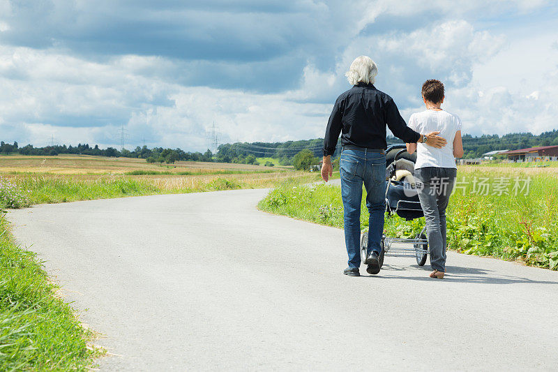 爷爷奶奶推着婴儿车带着孙子出去散步
