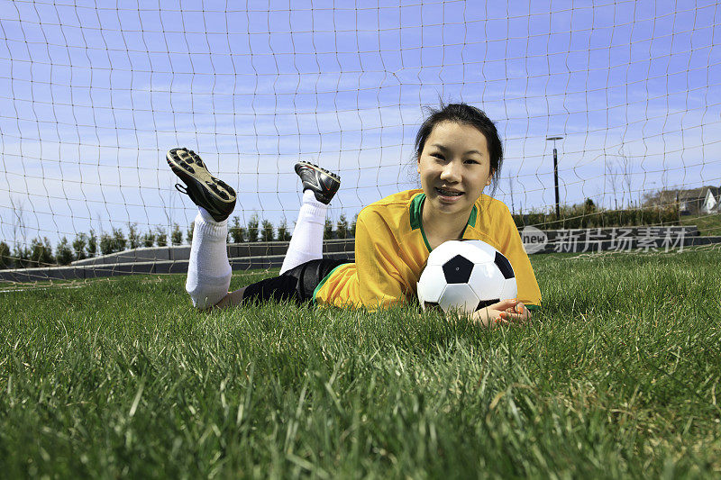 年轻女孩足球-躺在草地上