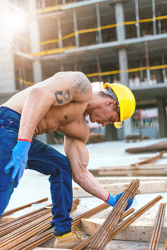 强壮的建筑工人搬运钢筋和电枢